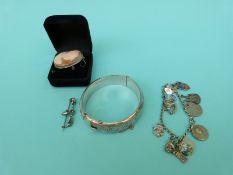 A hallmarked silver bangle, a silver charm bracelet,