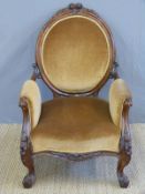 A 19thC carved walnut upholstered armchair raised on cabriole legs