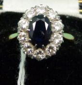 An 18ct gold ring set with an oval sapphire surrounded by round cut diamonds in Mappin & Webb box