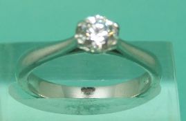 A platinum ring set with a modern round brilliant cut diamond measuring 0.
