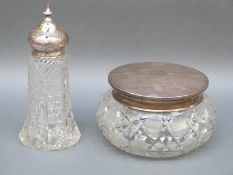 A large George V hallmarked silver lidded dressing table pot with cut glass base,