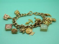 A quantity of 9ct gold charms including an elephant, owl, swan, church etc, on a gold plated chain.