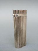 Cartier silver lighter with ridged design and sapphire cabochon,