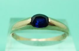 A yellow metal ring set with a sapphire (Size U)