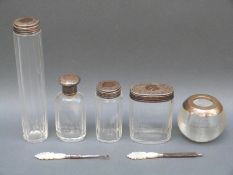 Four hallmarked silver topped bottles and silver mounted match striker.