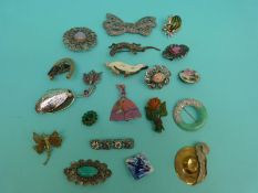 A collection of unusual brooches including a guilloche enamel example, a horse and horseshoe brooch,