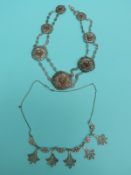 A white metal filigree necklace made up of tiered flower links and another white metal filigree