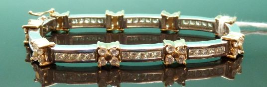 An 18ct gold bi-coloured bracelet set with 76 round cut diamonds in alternating cluster and channel