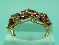 Three 9ct gold rings set with garnets and another set with quartz