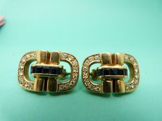 A pair of yellow metal earrings in the form of buckles,