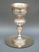 A German white metal communion cup with embossed decoration and gilt wash interior, height 20.