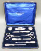 A cased George V hallmarked silver manicure set,