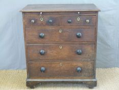 A Georgian oak bachelor's chest of two over three drawers with brushing slide above,