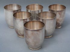 A set of six German white metal beakers with rope twist feet,