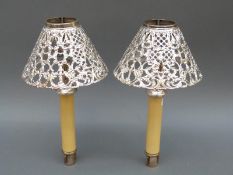 A pair of Gorham white metal pierced lamp shades with spring loaded candle bases,