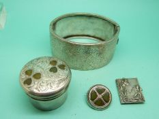 A large silver bangle with engraved foliate design,