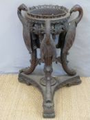 A carved Victorian jardiniere stand supported by three vultures, possibly Anglo Indian,