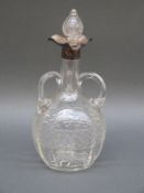 An Edward VII hallmarked silver mounted cut glass decanter with three handles and triform pouring