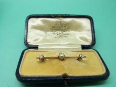 A Victorian brooch set with a pearl and two diamonds, with original box.