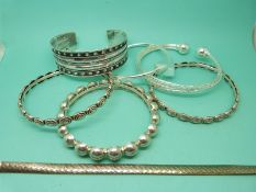 Six silver bangles and a silver bracelet.