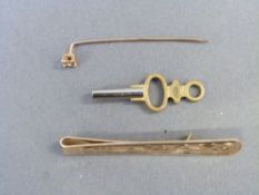 A 9ct gold tie clip and a 9ct gold stick pin set with a diamond