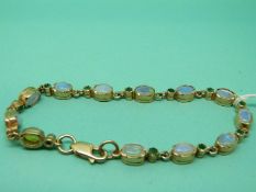 A 9ct gold bracelet set with opals and emeralds.