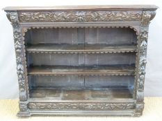 A Victorian carved oak bookcase with shaped top drawer,