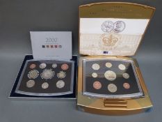 Two deluxe cased Royal Mint coin sets comprising 2002 Golden Jubilee and a 2000 Millennium
