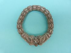 A white metal filigree bangle made up oblong links