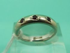 A 9ct white gold ring set with three rubies (Size K)