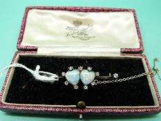A Victorian brooch with two heart shaped opal cabochons surrounded by diamonds,