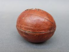 A novelty travelling inkwell in the form of a rugby ball,