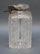 A hallmarked silver mounted cut glass tantalus decanter with Betjemann's patent mechanism,