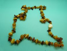 An amber necklace made up of irregular shaped opaque egg yolk coloured beads and irregular
