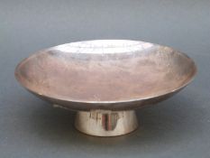 A modern white metal Oriental pedestal dish with possibly Chinese character marks to base,