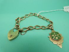 An Edwardian curb link bracelet with a 9ct gold fob decorated with enamel and a 9ct gold heart