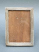 A small Art Deco hallmarked silver photograph frame with engine turned decoration and easel back,