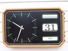 A circa 1970s light oak framed calendar/clock