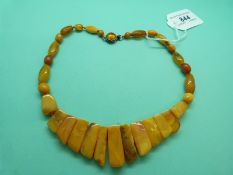 An Art Deco style amber necklace made up of egg yolk coloured graduated flat beads, 34g.