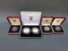 Four cases containing five silver 50 pence coins,