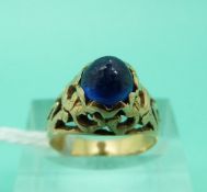 A yellow metal ring set with a blue cabochon (Size I)
