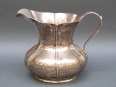 An Italian white metal jug of hammered Arts & Crafts design, marked Battuto A Mano 800, weight 422g,
