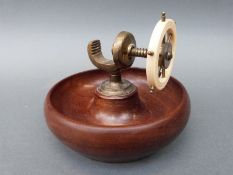 A retro turned wood and brass nutcracker in the form of a ship's wheel,