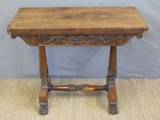 A 19thC rosewood fold over games table raised on lion paw feet,
