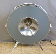 A retro Sofono electric heater raised on splayed metal legs,