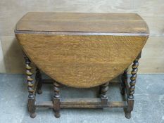 An oak drop leaf table with barley twist legs,