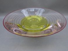 A large art glass flared bowl with yellow and red tinted decoration and spiral line design,