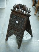 A 19thC carved Anglo Indian campaign style newspaper rack with elephant finials,