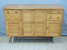 A retro Ercol light elm sideboard with an arrangement of four cupboard doors and four drawers inc