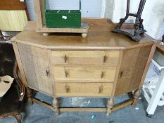 An Arts and Crafts influenced canted oak sideboard (H107 x W145 x D50cm)